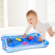A baby observing the dynamic movement of toys within the transparent Baby Water Mat.