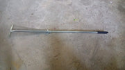 A gardener using the versatile garden rake to smooth soil in a neatly maintained yard.